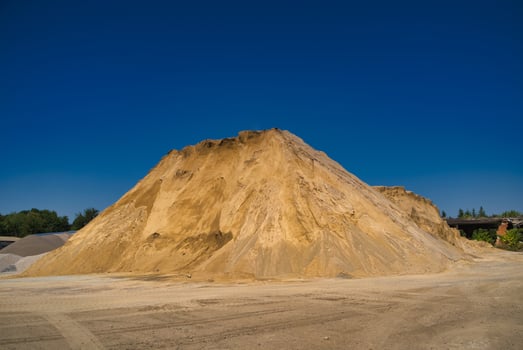 Sand slagheap for industrial needs. Blue sky background. Selective focus. photo