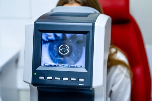 Woman looking at refractometer eye test machine in ophthalmology, vision correction concept photo