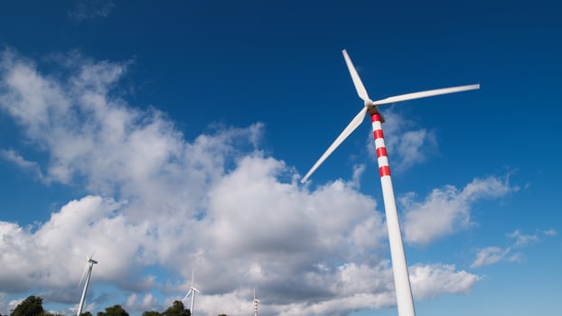 Suggestive natural landscape with white clouds and wind turbines photo