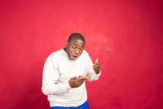 Portrait of a joyful young man holding mobile phone photo