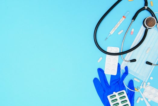 Top view of medicines, work tools and accessories doctor, nurse. Medical set - Tablets, thermometer, syringe, ampoules, adhesive plaster and statoscope on a blue background. Flat lay. photo