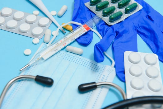 Top view of medicines, work tools and accessories doctor, nurse. Medical set - Tablets, thermometer, syringe, ampoules, adhesive plaster and statoscope on a blue background. Flat lay. photo