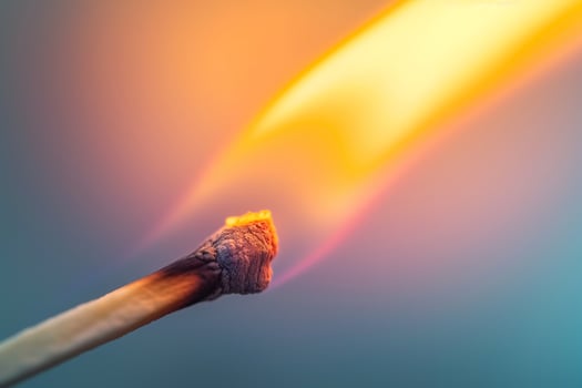 AI generated burning match close-up on a blue background photo