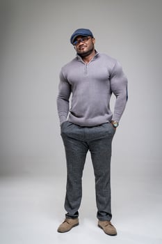 Handsome fashionable model posing for camera. Athletic man in hat looking into camera. photo