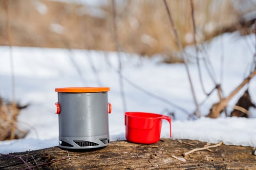 Aluminum light pot for cooking in nature, camping utensils, a metal pan, a red mug, climber's equipment objects. photo