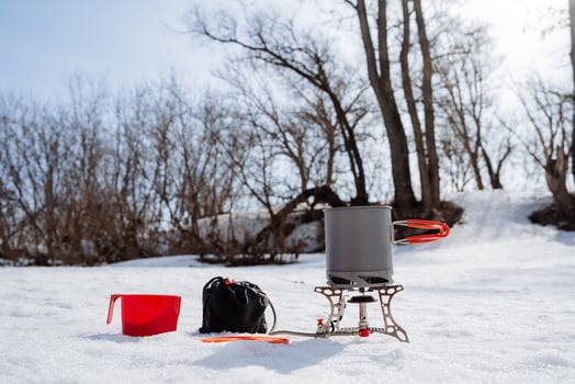 Extreme breakfast in the forest, cooking against the background of the forest, winter hiking in the snow, boiling water to brew tea, tourist dishes, survival in nature, camping in the snow. photo