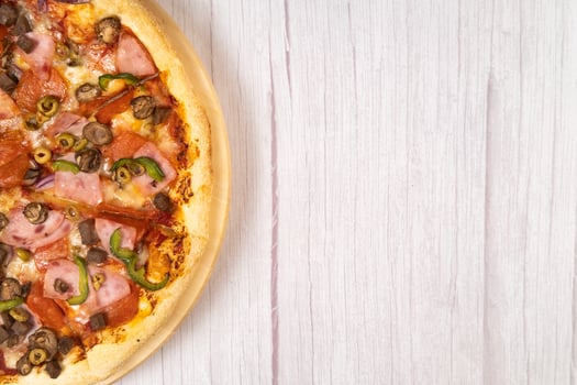 Delicious large pizza with veal and mushrooms on a light wooden background photo