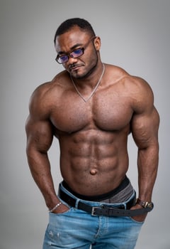 Strong African guy with big biceps and great abs standing photo