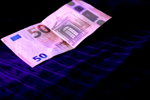 Money. 50 euro banknote being examined under ultraviolet light on a dark cloth photo