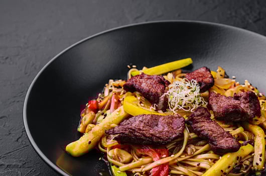 Chinese noodles with roasted duck and fried vegetables photo