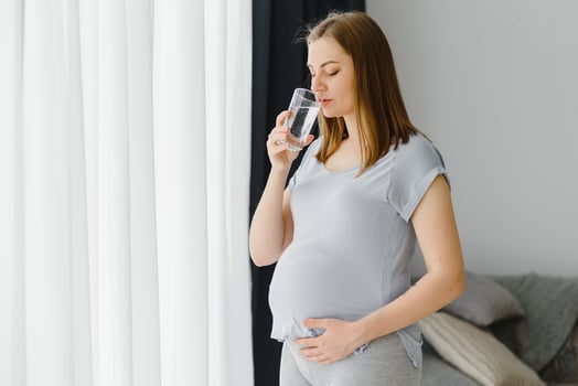 Portrait of a lovely pregnant woman drinking water photo