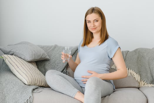 Portrait of a lovely pregnant woman drinking water photo