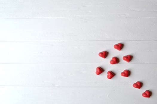 Red candies on the white wooden table. Background for greeting card on Valentine's day with place for text. photo
