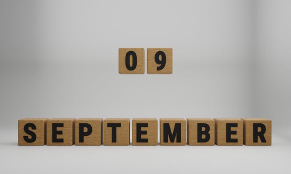 wooden cubes with arranged letters. September and 09 on blurry white background photo