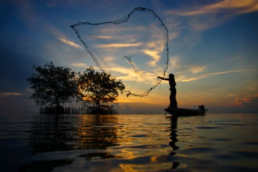Silhouettes fisherman throwing fishing nets photo