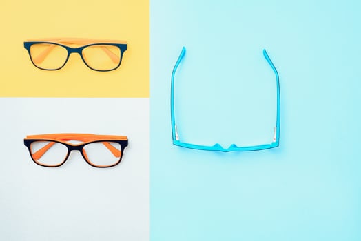 Stylish eyeglasses over background. Optical store, glasses selection, eye test, vision examination at optician, fashion accessories concept. Top view, flat lay photo