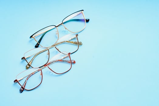 pair of red plastic-rimmed eyeglasses on a blue background photo