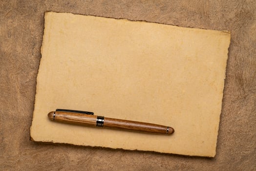 sheets of blank handmade paper with rough edges and a stylish pen against textured bark paper photo