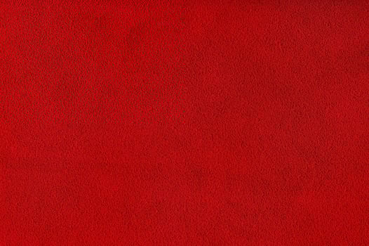 Red velvet background studio photo. Macro photo of natural red-dyed suede.