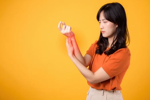 Portrait of a young lady indicating wrist discomfort. Illustrating body ache and joint inflammation due to health issues. photo