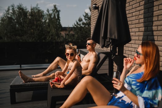 A happy family in swimsuits sunbathe in summer on their terrace on sun beds photo
