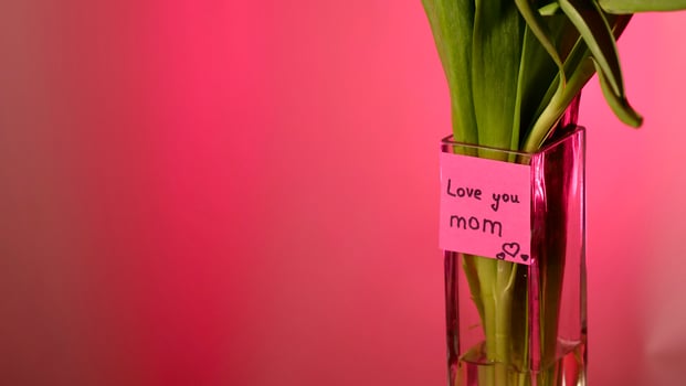 Spring tulip flowers on pink background , close-up with space for paste text. International Mother's Day. Sticker I love you mom, copy space , neon magenta light photo
