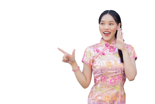 Asian woman with long hair who wears pink Cheongsam dress in Chinese new year theme while her hand shows to present and showing hand to point while isolated white background. photo