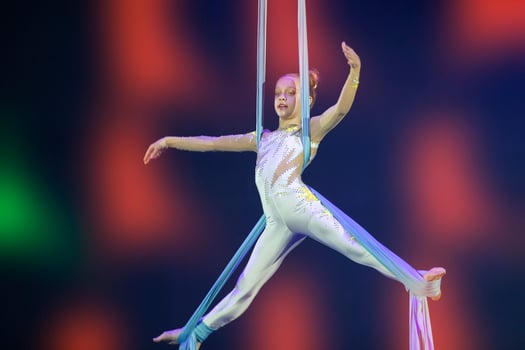 Performance by a circus acrobat artist. Girls perform aerial acrobatic elements on fabric. photo