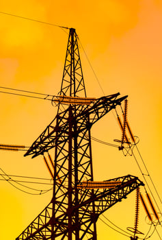 High voltage power lines with electricity pylons at dusk. Beautiful orange sunset. Golden sky background. photo