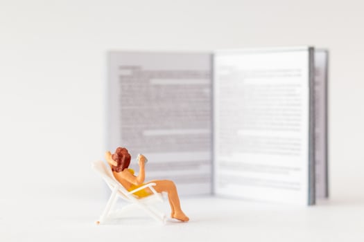 World Book Day concept, Miniature people A young woman reading a book alone photo