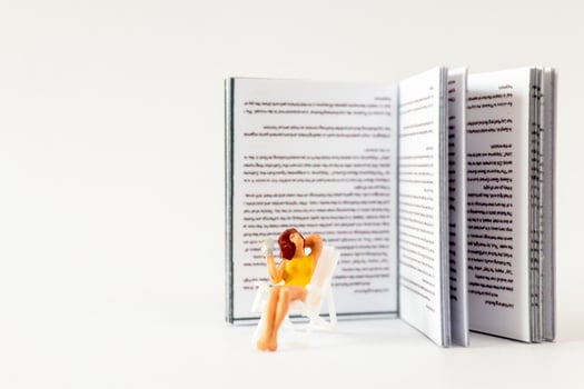 World Book Day concept, Miniature people A young woman reading a book alone photo