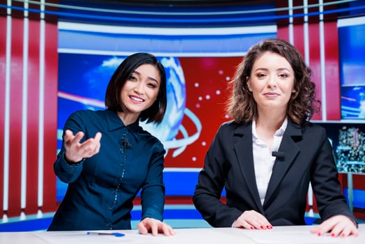 Journalists team discuss daily news, presenting latest events on international television program in newsroom. Two women broadcasters working on entertainment segment with reportage. photo