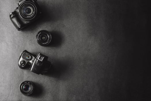 Professional cameras with different lenses on a black background. photo