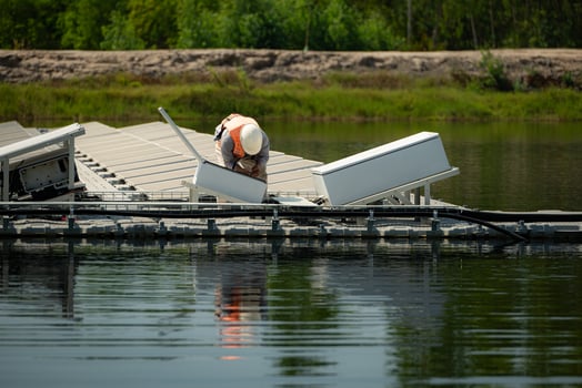 Technician currently evaluating and repairing the transmission terminals for electricity generated by solar energy in a floating solar power system. photo