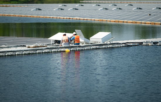 Both of technicians are currently evaluating and repairing the transmission terminals for electricity generated by solar energy in a floating solar power system. photo