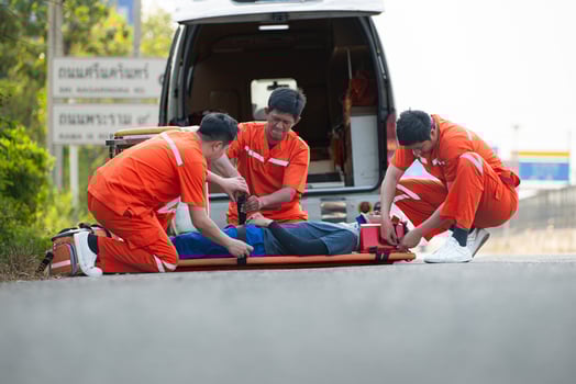 The paramedic  is assisting an injured man in an emergency situation on the road. photo