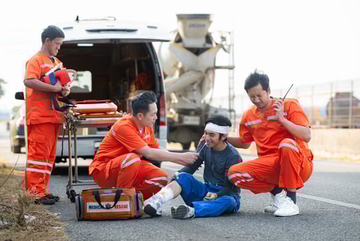 The paramedic  is assisting an injured man in an emergency situation on the road. photo