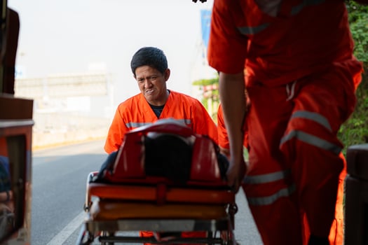 The paramedic  is assisting an injured man in an emergency situation on the road. photo
