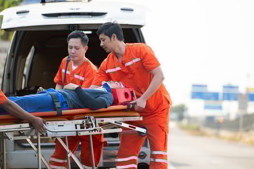 The paramedic  is assisting an injured man in an emergency situation on the road. photo