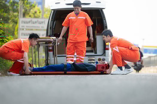 The paramedic  is assisting an injured man in an emergency situation on the road. photo