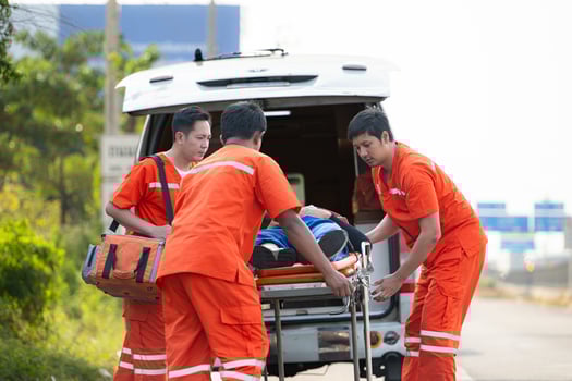 The paramedic  is assisting an injured man in an emergency situation on the road. photo