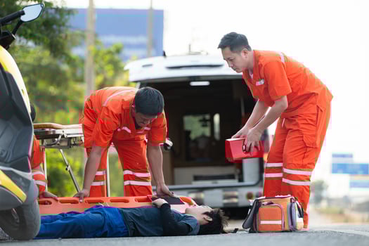 The paramedic  is assisting an injured man in an emergency situation on the road. photo