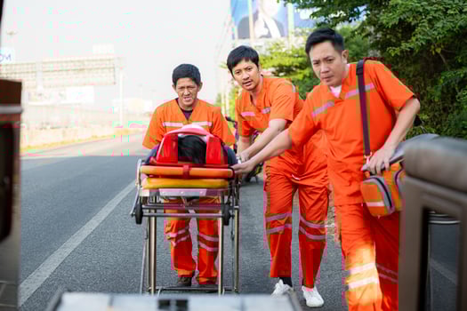 The paramedic  is assisting an injured man in an emergency situation on the road. photo