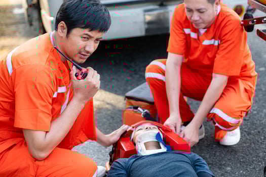 The paramedic  is assisting an injured man in an emergency situation on the road. photo
