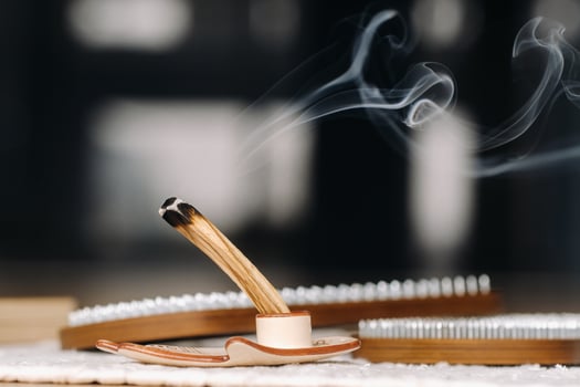 A smoking Palo Santo stick and boards with nails for yoga classes photo