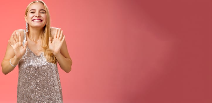 Excited happy charming birthday blond girl celebrating having fun partying smiling broadly carefree closed eyes rejoice grin dancing raise palms head up standing joyful stylish silver dress photo