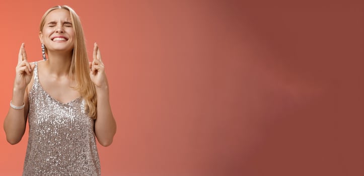 Worried blond woman put effort god hear prayers intense close eyes clench teeth raise head up praying supplicating cross fingers good luck wanna win dream come true making wish, red background photo
