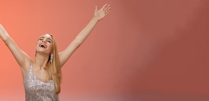 Waist-up carefree happy girl fulfill dream raising hands up sky joyfully close eyes smiling celebrating good perfect news triumphing achieve success victory, standing thrilled red background photo