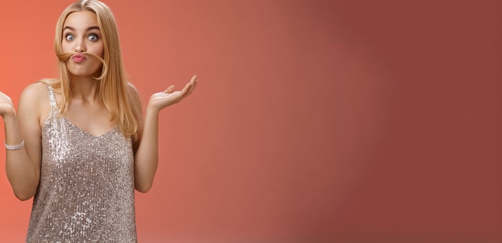 Who told I adult. Playful carefree funny charming blond woman make moustache from hair strand mimicking old man shrugging hands sideways questioned fool around playing red background photo