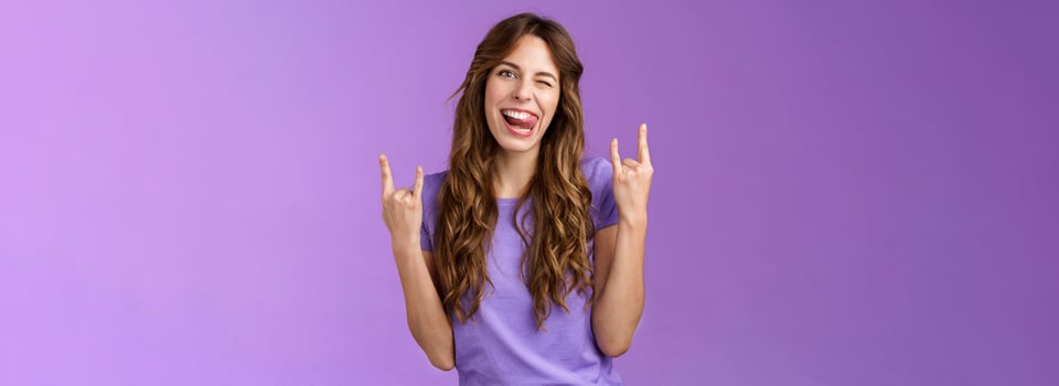 Daring sassy funny attractive woman having fun enjoy awesome party arrange music concert gathering show rock-n-roll heavy metal sign joyful stick tongue wink cheeky purple background photo